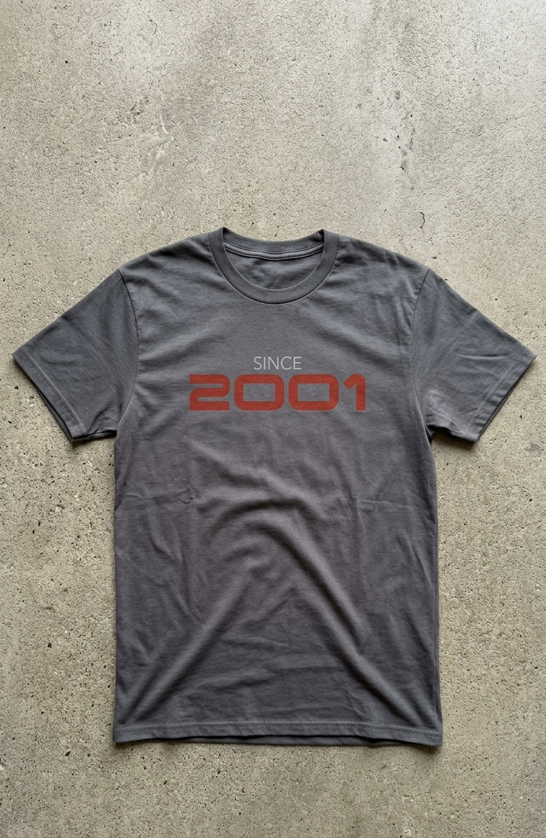 Gray t-shirt with 'Since 2001' text on a concrete surface