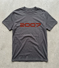 Gray t-shirt with 'Since 2007' text in red on a concrete surface