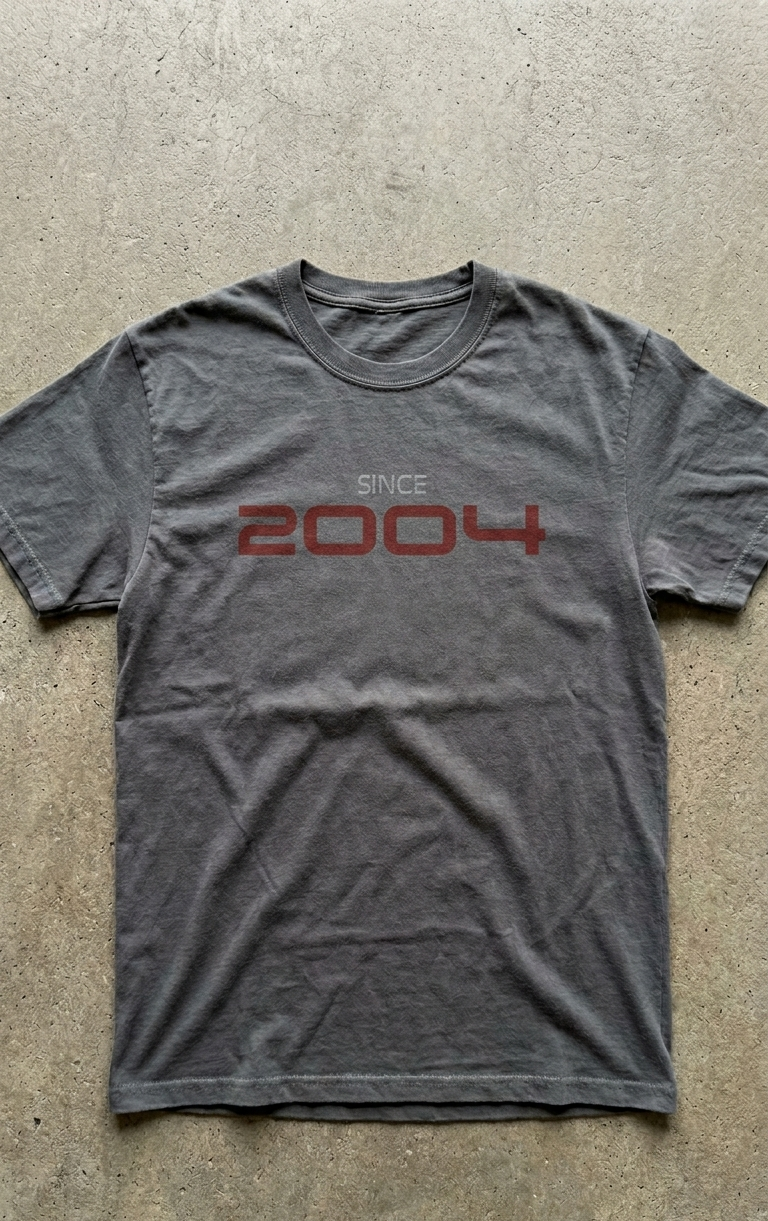 Gray t-shirt with 'Since 2004' text on a concrete floor